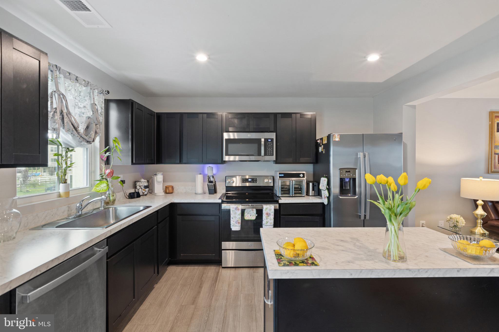 1049 Wickersham Way Middletown, DE 19709 - Photo 15 of 33 a kitchen with stainless steel appliances granite countertop a sink a stove top oven a counter space and cabinets
