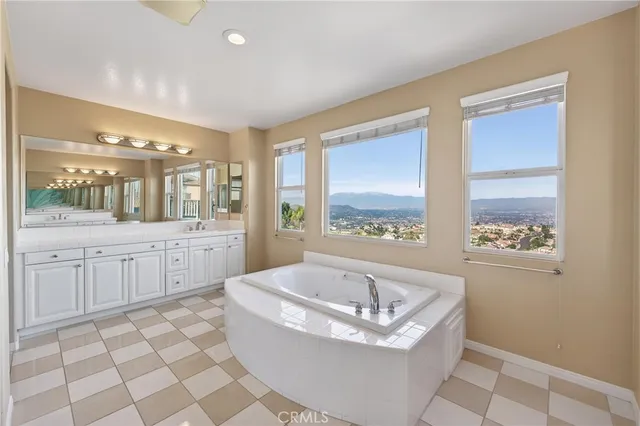 a spacious bathroom with a bathtub a mirror a sinks a vanity and a shower