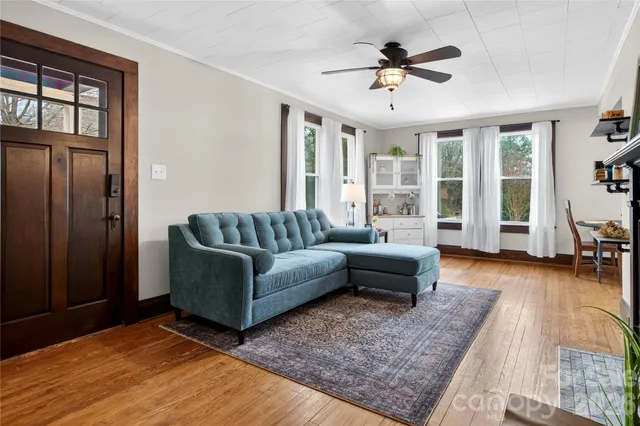 a living room with furniture and a large window with wooden floor