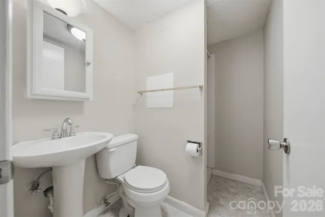 a bathroom with a sink toilet and a mirror