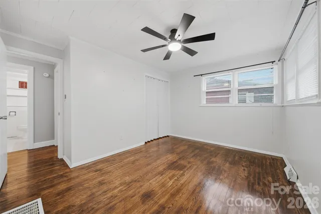 a view of a big room with wooden floor and windows