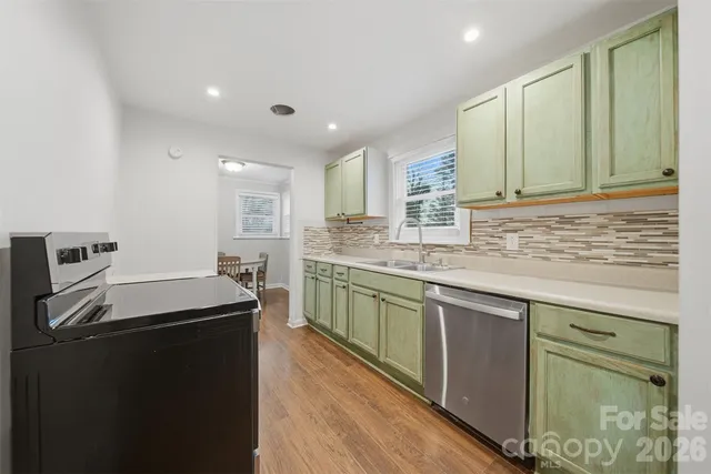 a kitchen with granite countertop cabinets sink and white stainless steel appliances