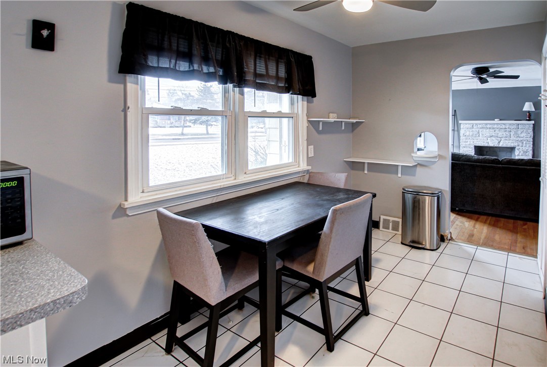 3434 West Pleasant Valley Road Cleveland, OH 44134 - Photo 5 of 34 Tiled dining area with a fireplace and ceiling fan