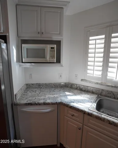 a kitchen with stainless steel appliances granite countertop a sink stove and microwave