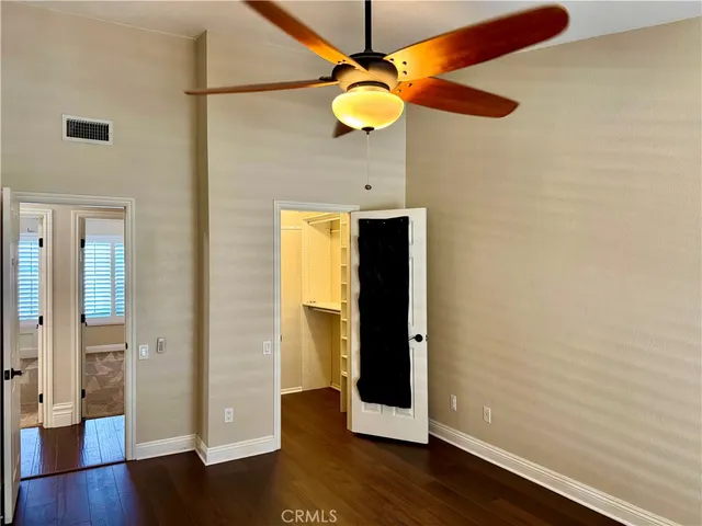 a room with wooden floor and ceiling fan