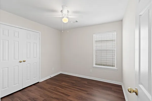an empty room with wooden floor and window