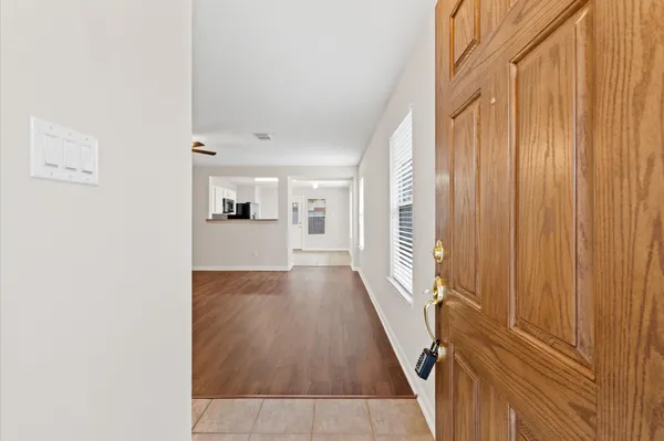 a view of a hallway with wooden floor and staircase
