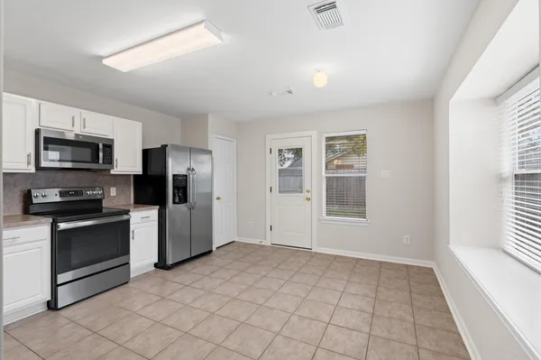 a view of a kitchen with microwave and refrigerator