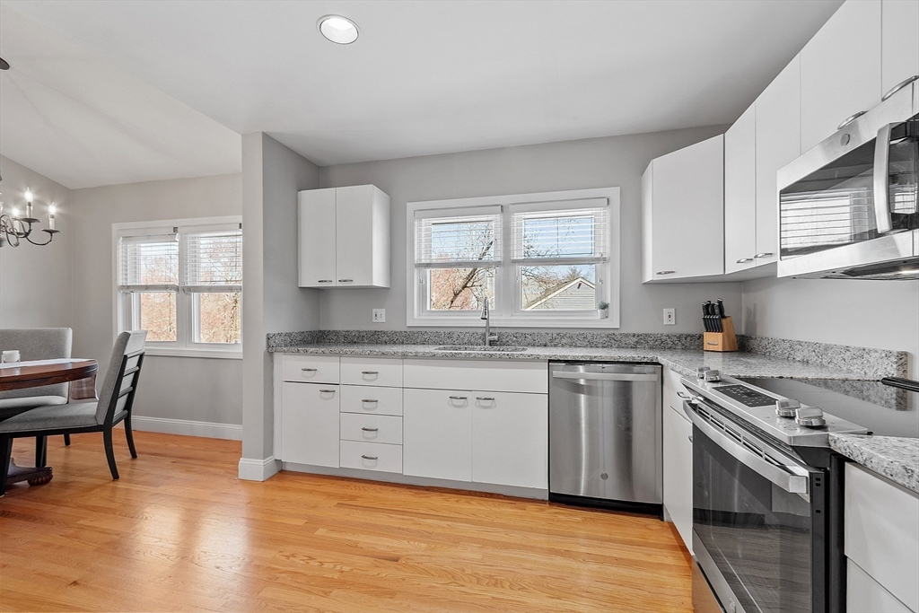 13 Boulderbrook Drive, Unit 13 Peabody, MA 01960 - Photo 4 of 41 a kitchen with granite countertop a stove a sink and a wooden floors
