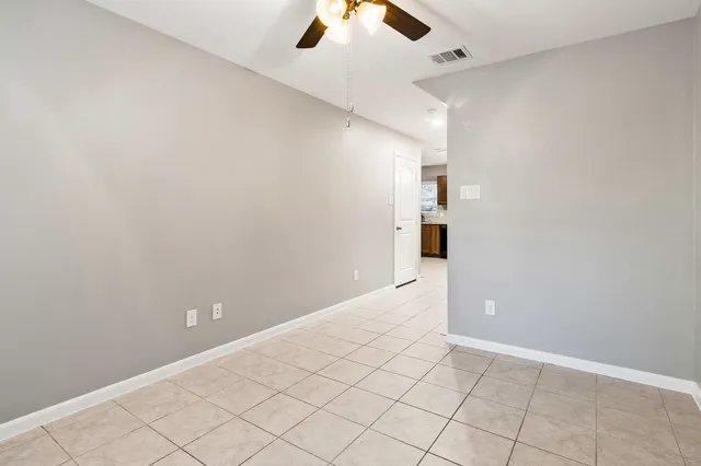 an empty room and chandelier fan