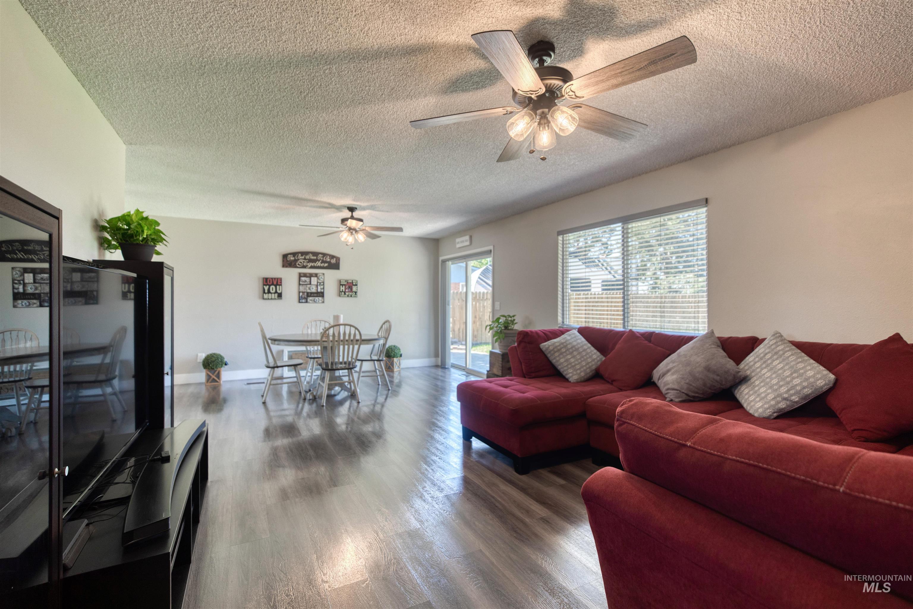 20803 Friends Road Greenleaf, ID 83626 - Photo 37 of 39 Open-concept living area featuring wood-finish flooring, a dining space, and multiple windows