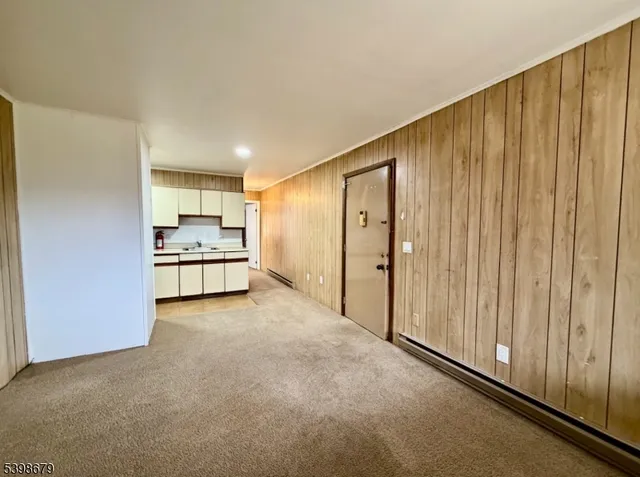 a view of kitchen with stainless steel appliances wooden floor and window