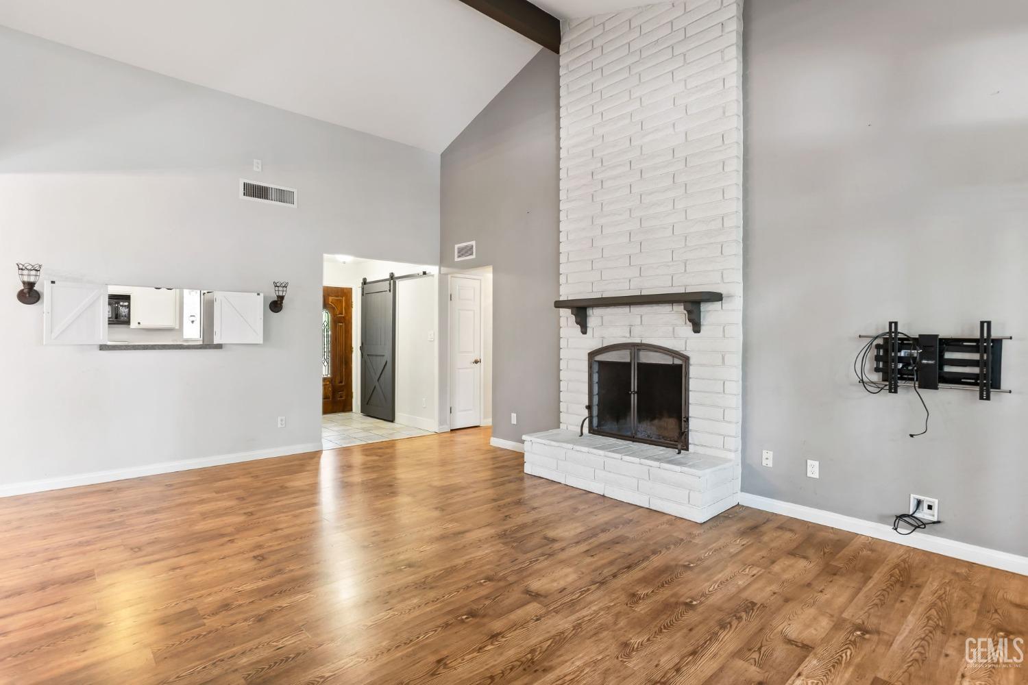 Undisclosed Address Bakersfield, CA 93306 - Photo 11 of 61 a view of a livingroom with a fireplace a ceiling fan and windows