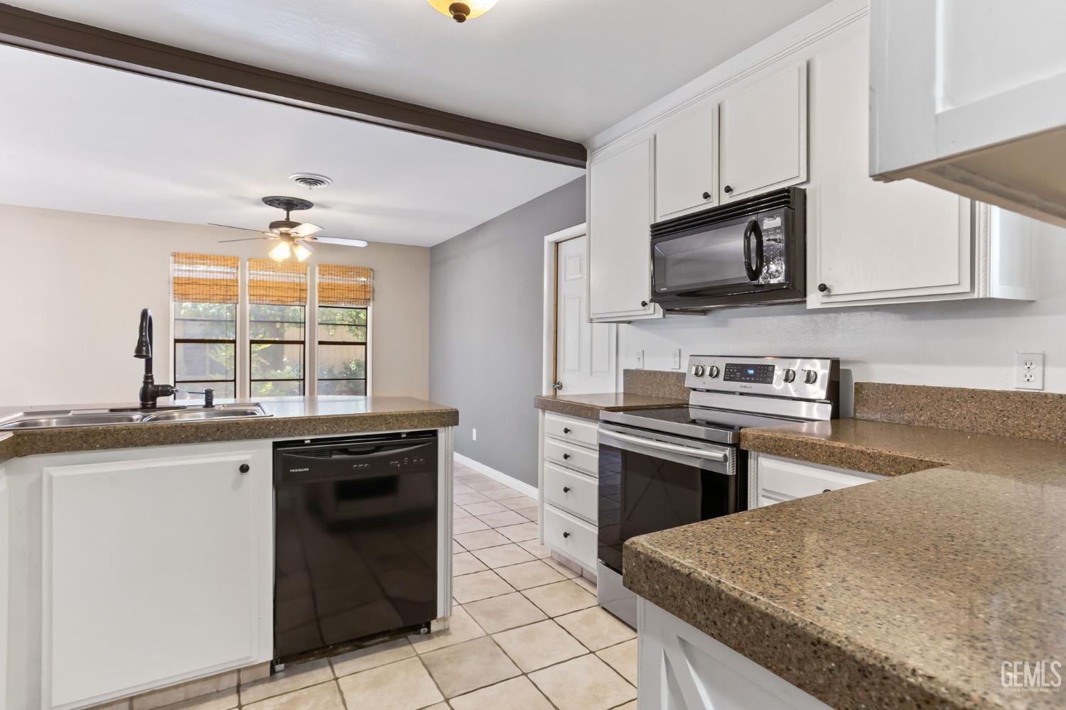 Undisclosed Address Bakersfield, CA 93306 - Photo 16 of 61 a kitchen with stainless steel appliances granite countertop a stove a sink and a microwave