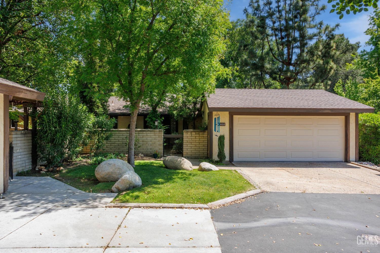 Undisclosed Address Bakersfield, CA 93306 - Photo 2 of 61 a front view of a house with a yard and garage