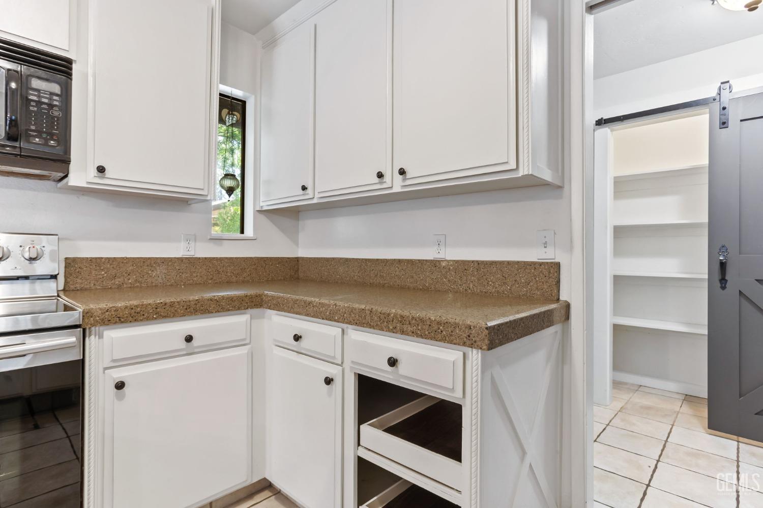 Undisclosed Address Bakersfield, CA 93306 - Photo 21 of 61 a kitchen with granite countertop white cabinets and white appliances