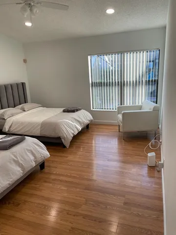 a bedroom with two beds and wooden floor