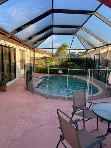a view of a chairs and table in the patio and a backyard
