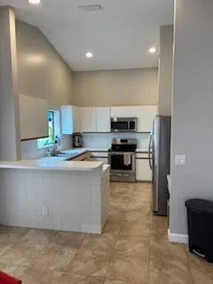 a kitchen with kitchen island granite countertop a stove a sink and a refrigerator