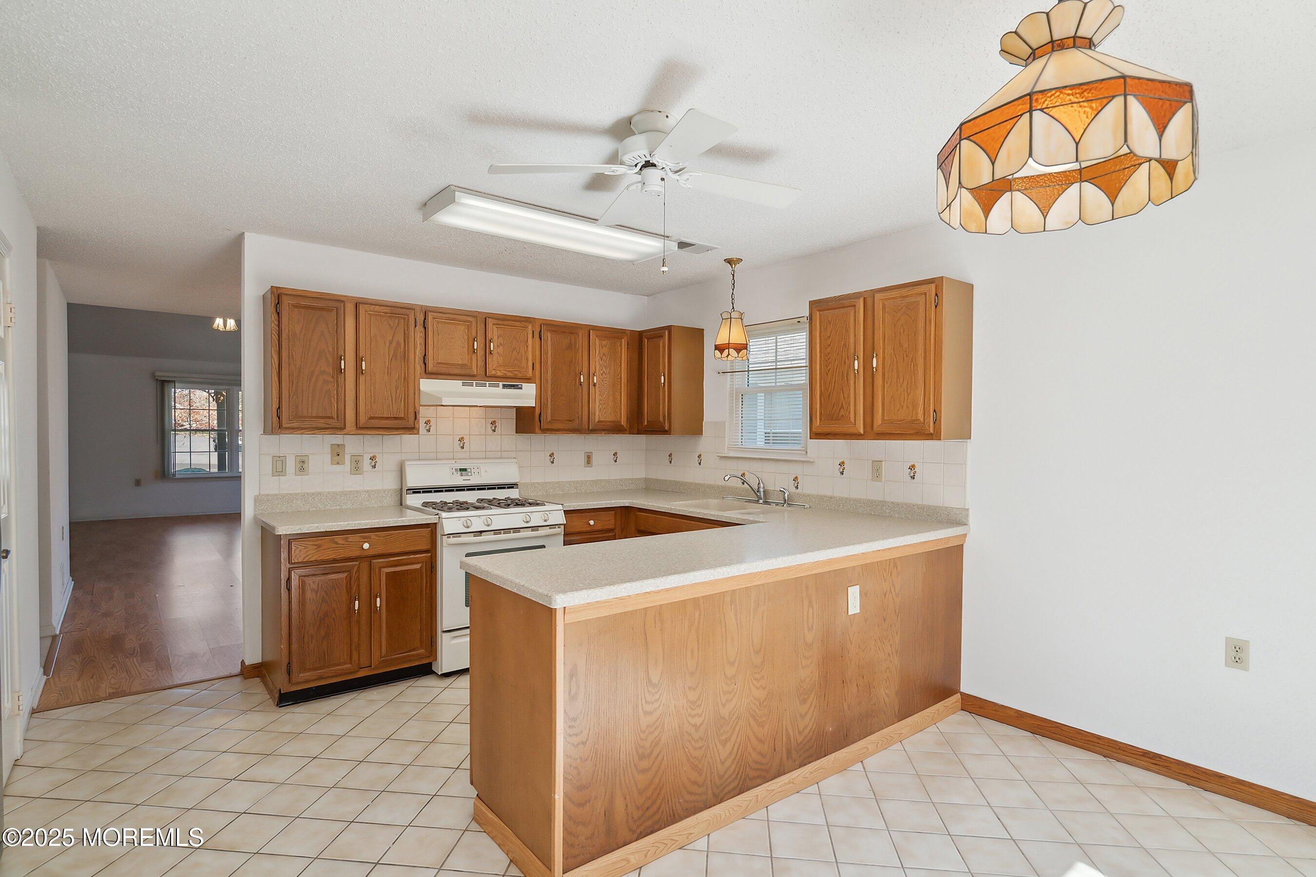 32 Pine Oak Boulevard Barnegat, NJ 08005 - Photo 16 of 40 a kitchen with stainless steel appliances a stove a sink and a refrigerator