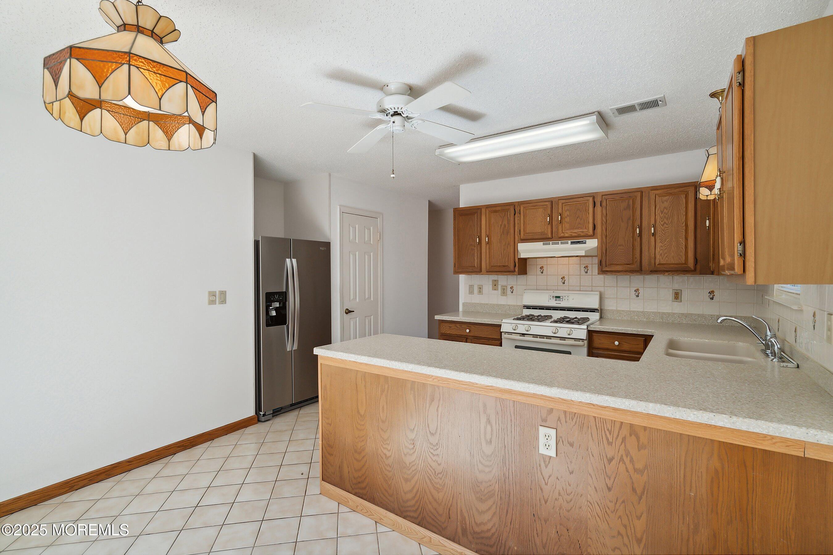 32 Pine Oak Boulevard Barnegat, NJ 08005 - Photo 17 of 40 a kitchen with stainless steel appliances a refrigerator a sink a stove a microwave and cabinets