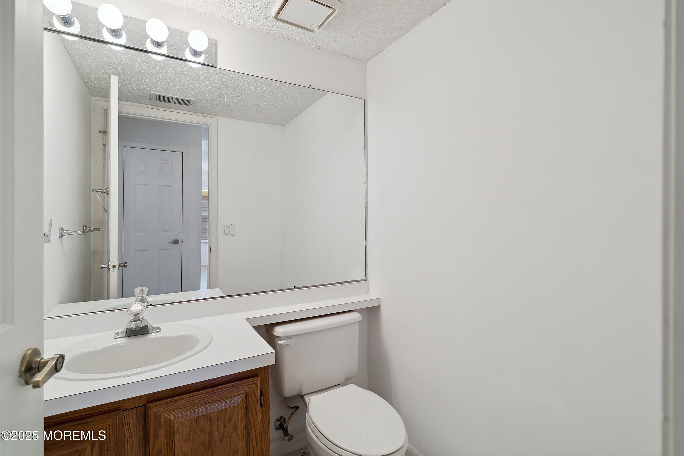 32 Pine Oak Boulevard Barnegat, NJ 08005 - Photo 20 of 40 a bathroom with a toilet a sink and mirror