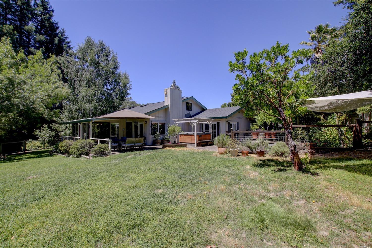 a view of a house with backyard garden and sitting area