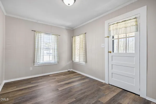 a view of empty room with wooden floor