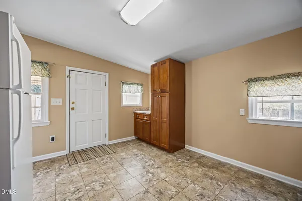 a kitchen with refrigerator cabinets and wooden floor