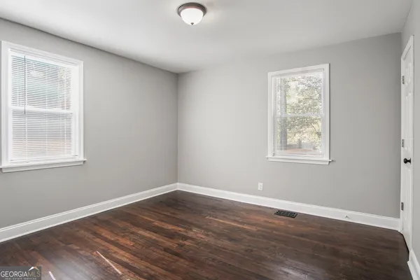 a view of a room with wooden floor and windows