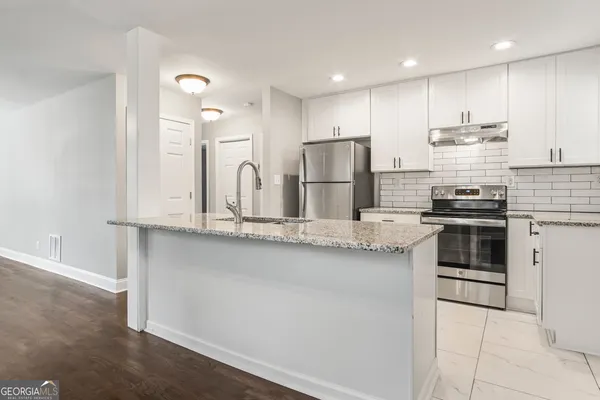 a kitchen with stainless steel appliances granite countertop a stove a sink and a refrigerator