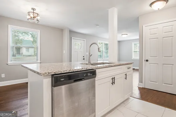 a kitchen with granite countertop a sink and cabinets