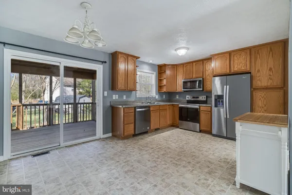 a kitchen with stainless steel appliances granite countertop a refrigerator a sink a stove with cabinets