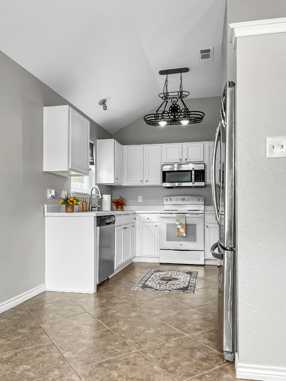 4701 High Pointe Drive Temple, TX 76502 - Photo 6 of 10 Kitchen featuring vaulted ceiling, appliances with stainless steel finishes, white cabinetry, light countertops, and light tile patterned flooring