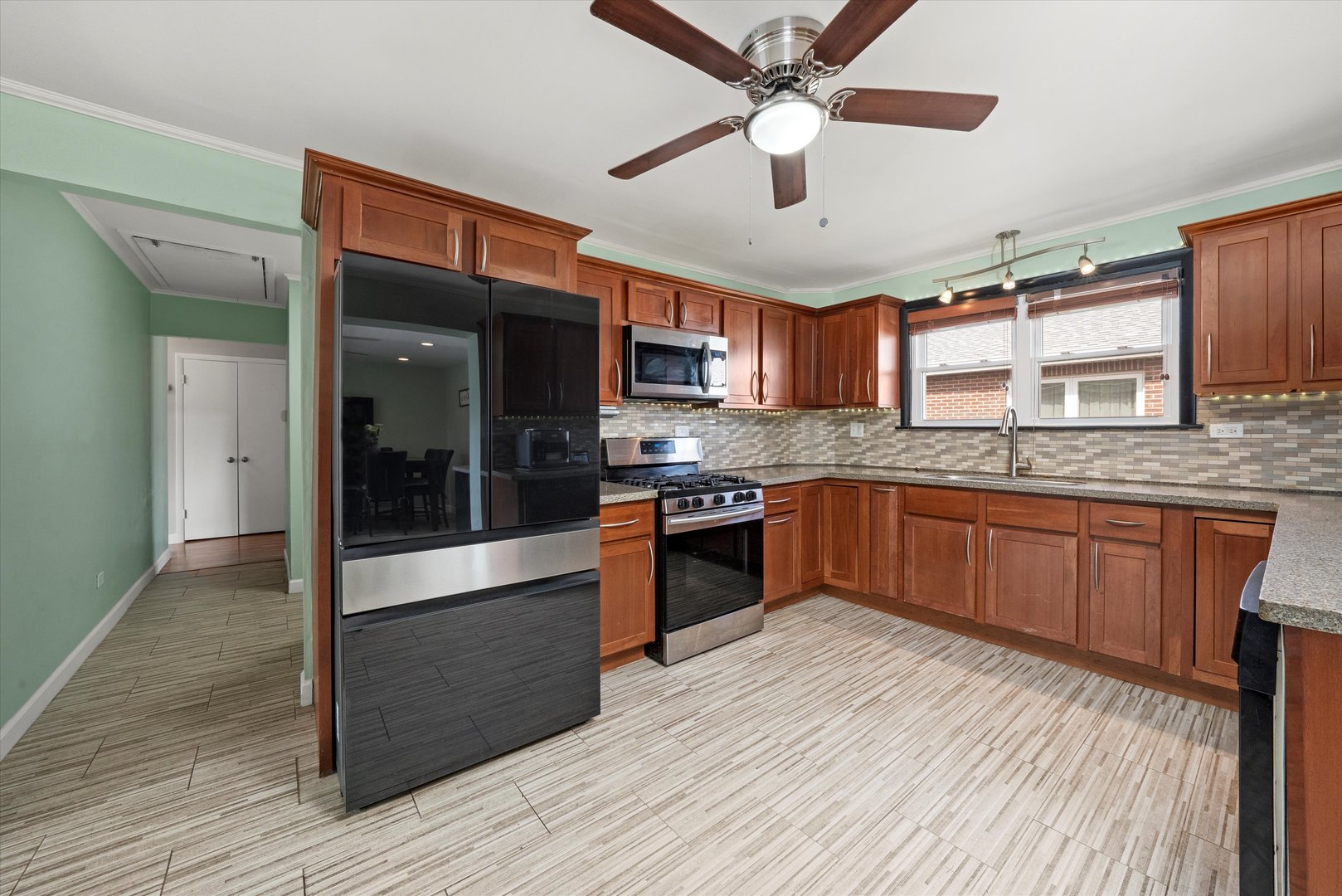 5730 West 110th Street Chicago Ridge, IL 60415 - Photo 12 of 43 a kitchen with stainless steel appliances granite countertop wooden floors and view of living room