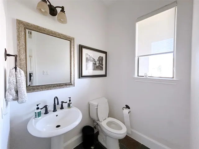 a bathroom with a toilet a sink and mirror