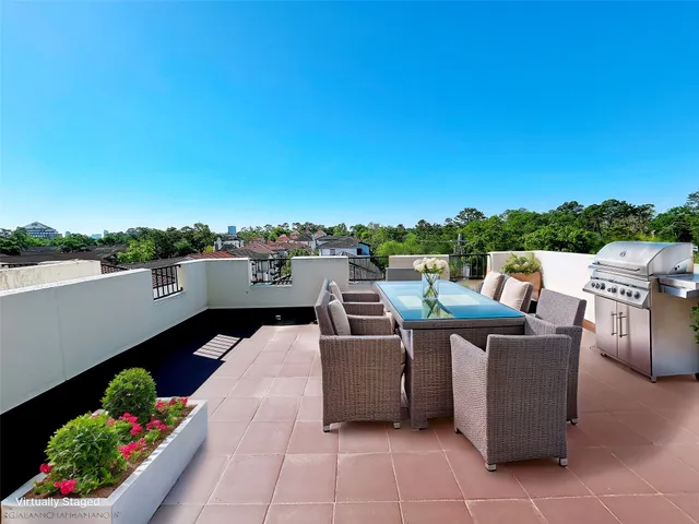 a roof deck with couches and potted plants