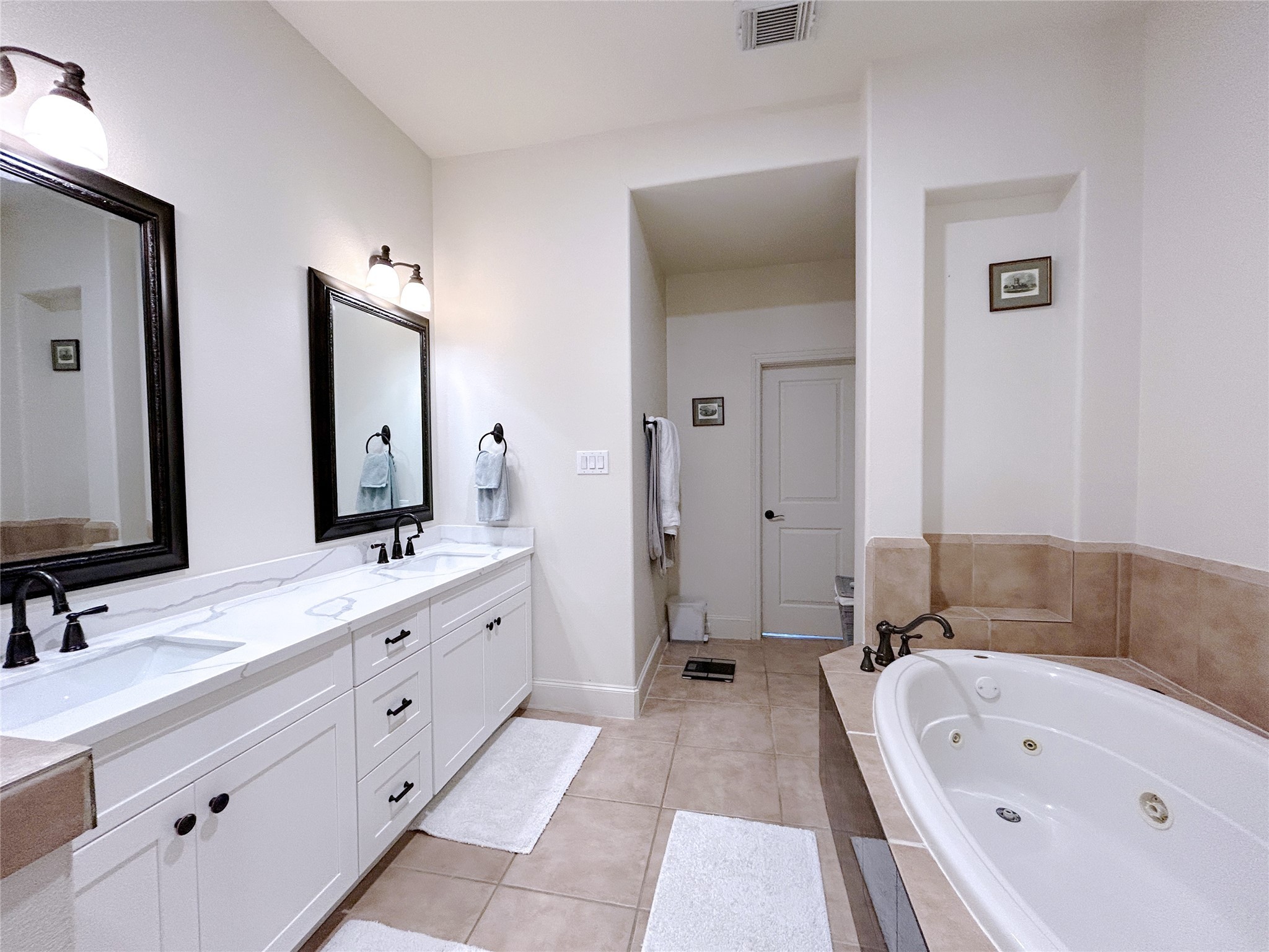 939 Queen Annes Road Houston, TX 77024 - Photo 36 of 40 a bathroom with a tub a double vanity sink double and mirror