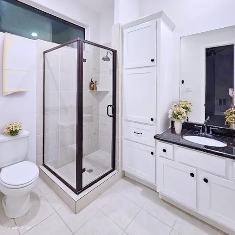 a bathroom with a shower sink mirror and toilet