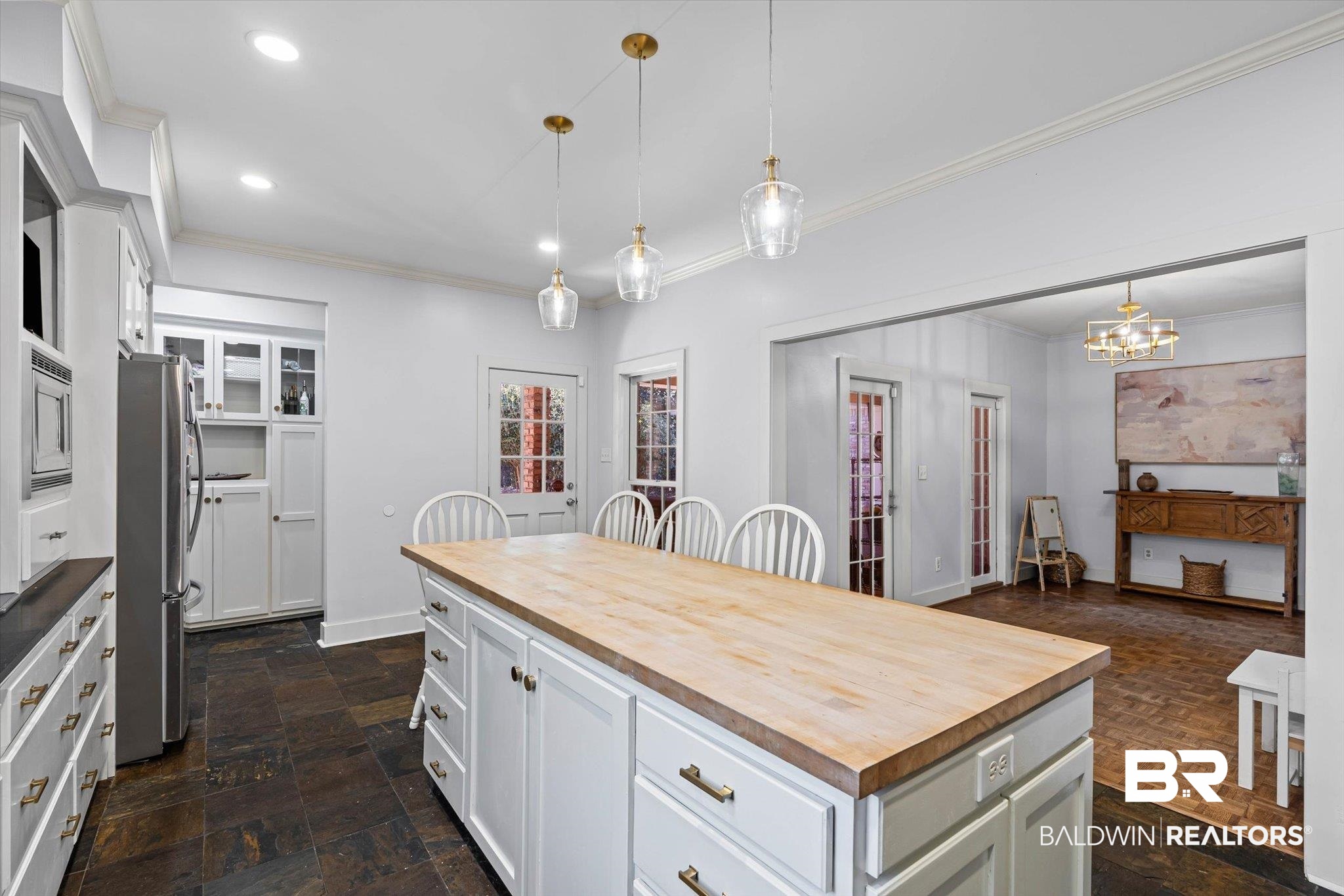 4776 Falls Church Road Mobile, AL 36608 - Photo 10 of 45 Kitchen featuring a large center island with a wood countertop, white cabinetry with brass hardware, and dark stone-finish flooring