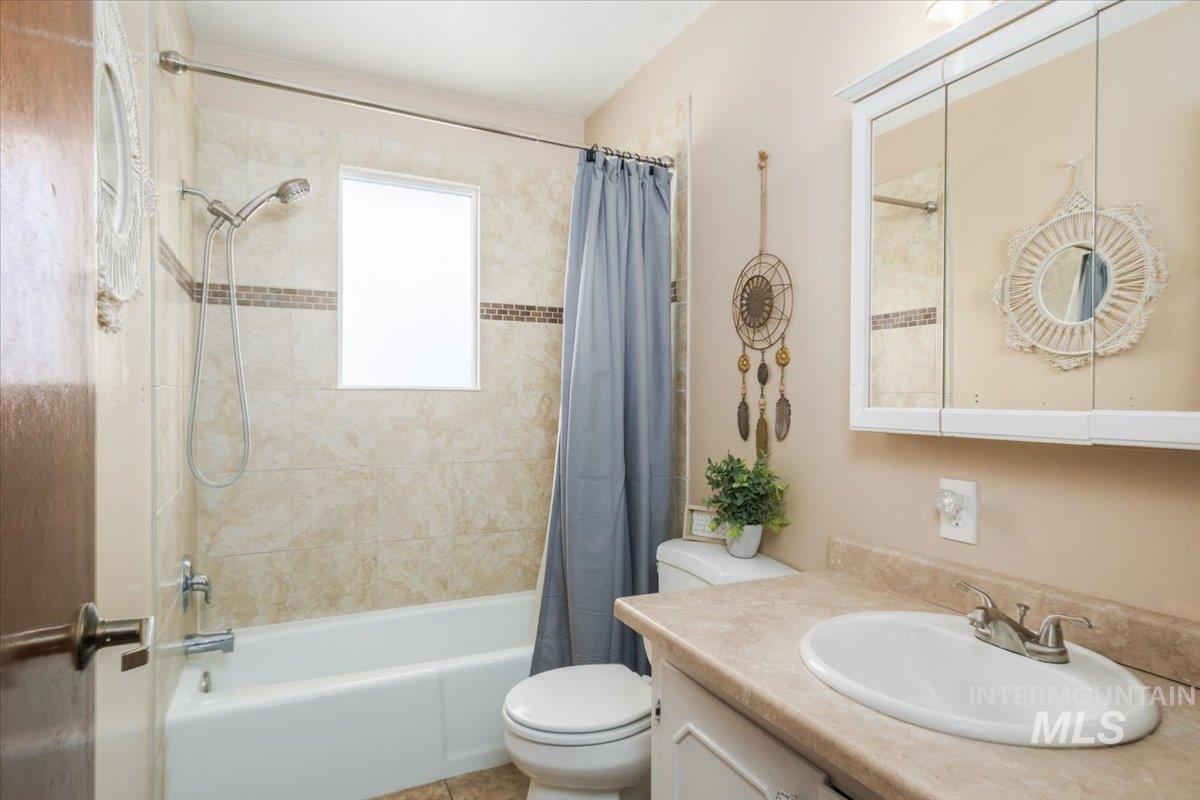 1401 Chokecherry Drive Pocatello, ID 83204 - Photo 32 of 46 Bathroom featuring a white bathtub, ceramic tile surround with mosaic accent, and a window