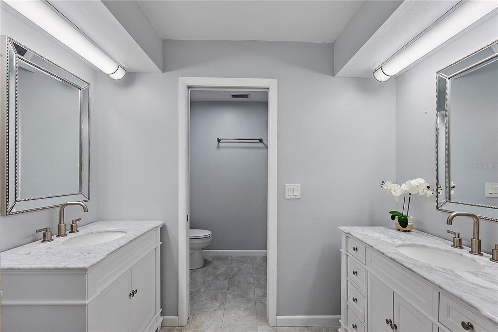 700 Starkey Road, Unit 1525 Largo, FL 33771 - Photo 18 of 46 a bathroom with a granite countertop sink toilet and mirror