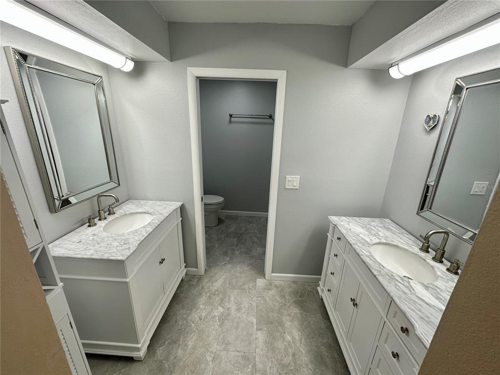 700 Starkey Road, Unit 1525 Largo, FL 33771 - Photo 19 of 46 a bathroom with a granite countertop sink toilet and mirror