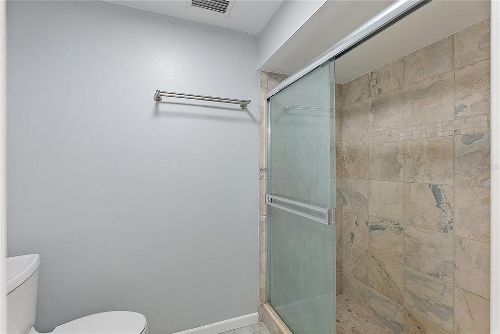 700 Starkey Road, Unit 1525 Largo, FL 33771 - Photo 23 of 46 a bathroom with a granite countertop shower and a toilet