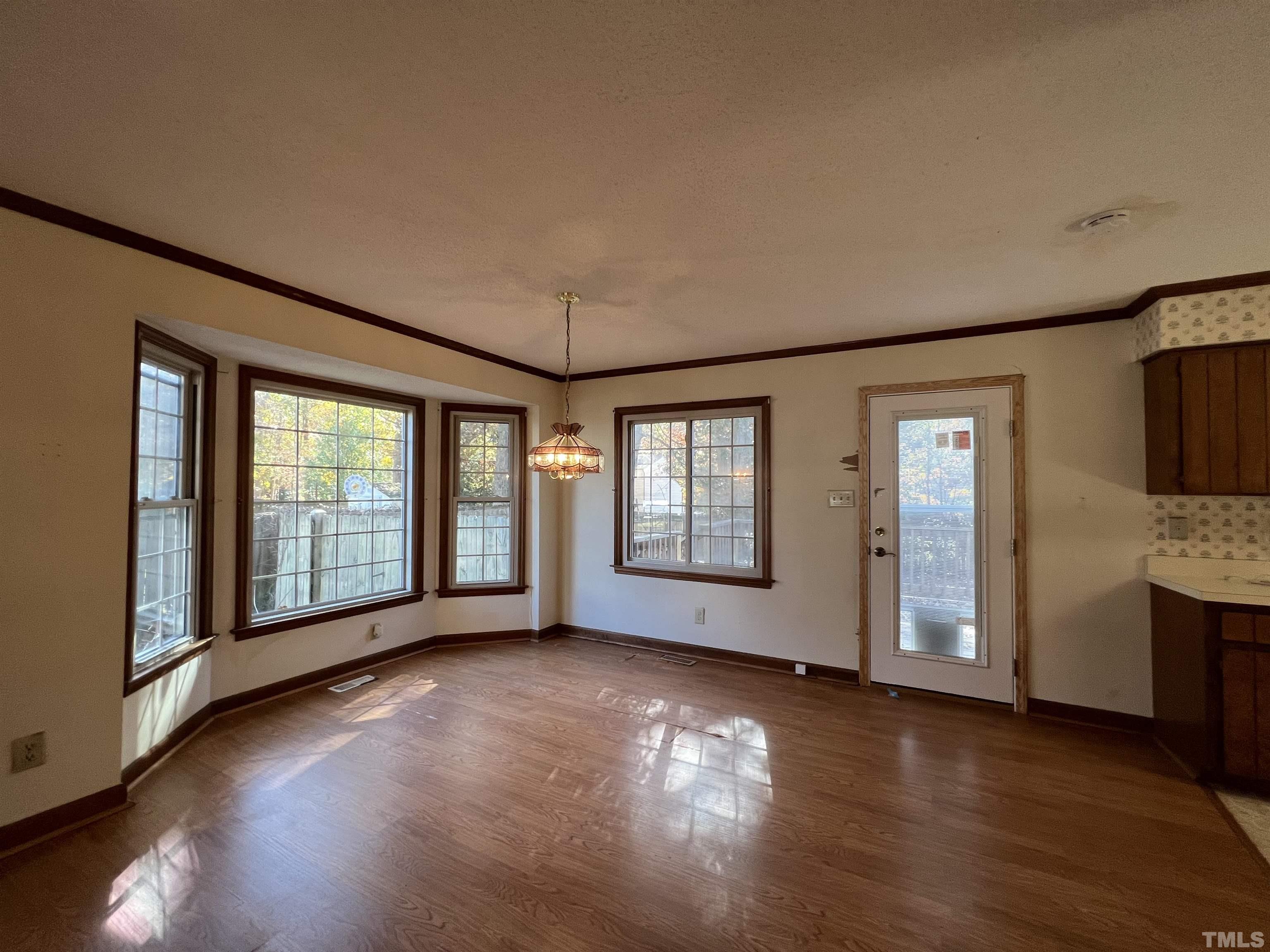 2509 Sawmill Road Raleigh, NC 27613 - Photo 14 of 22 a view of an empty room with a window and wooden floor
