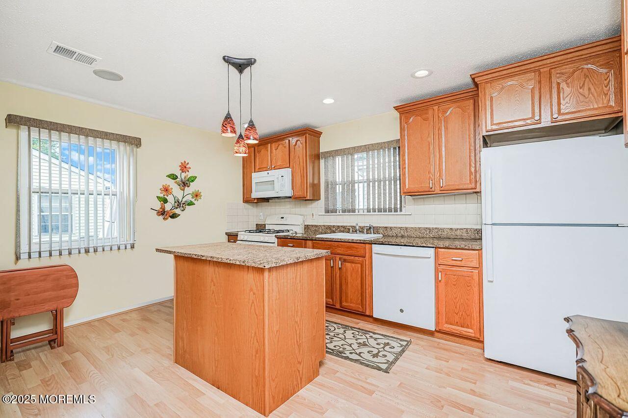 35 Ivy Ridge Close Freehold, NJ 07728 - Photo 5 of 18 a kitchen with stainless steel appliances granite countertop a sink a stove a refrigerator cabinets and living room view