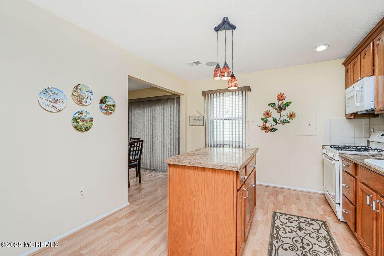 35 Ivy Ridge Close Freehold, NJ 07728 - Photo 7 of 18 a very nice looking room with a dining table a stove a refrigerator with wooden floor