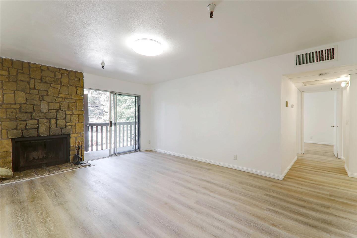 1775 Panda Way, Unit 103 Hayward, CA 94541 - Photo 13 of 33 an empty room with wooden floor fireplace and windows