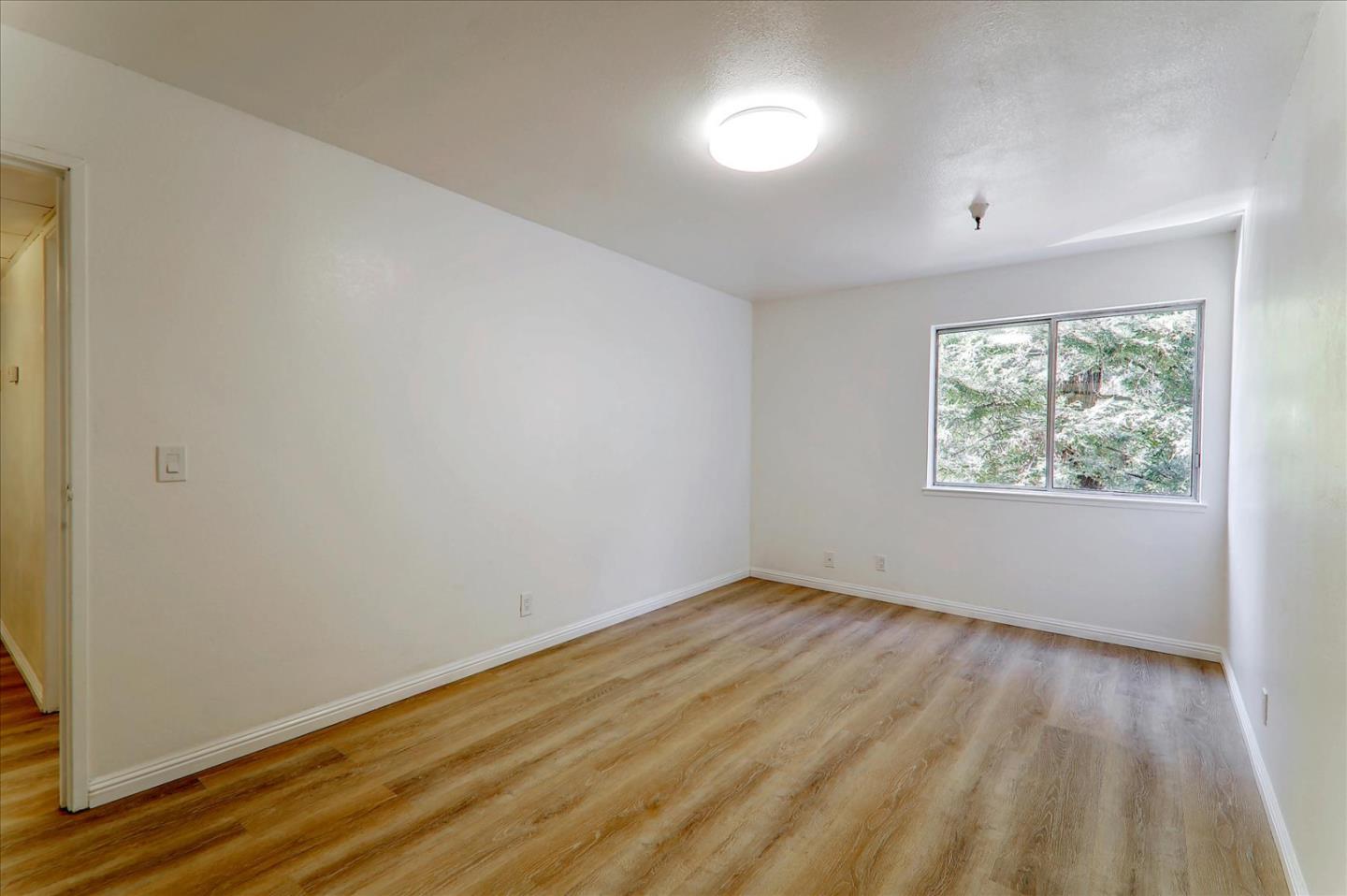 1775 Panda Way, Unit 103 Hayward, CA 94541 - Photo 19 of 33 an empty room with wooden floor and windows