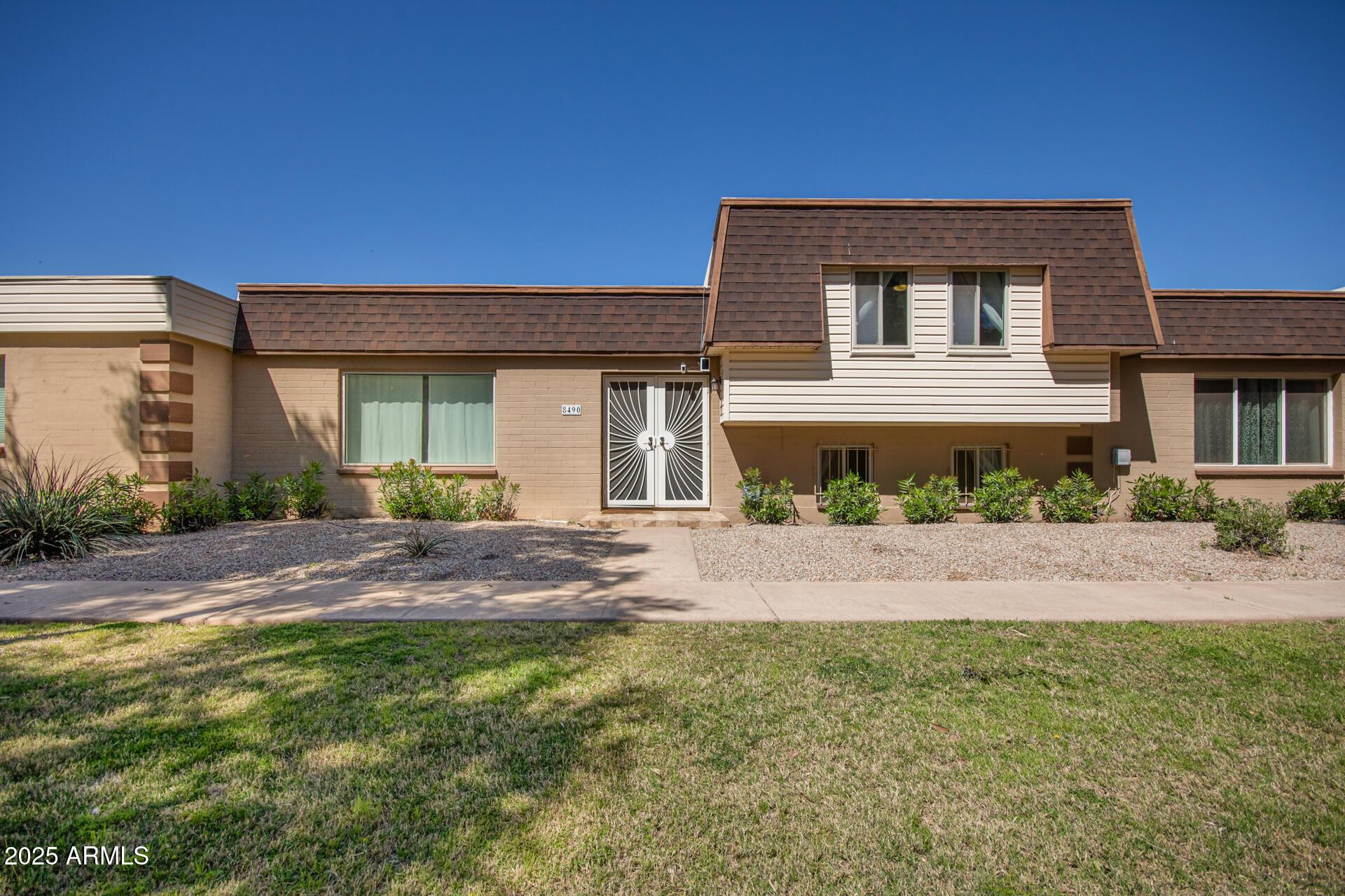 8490 East Chaparral Road Scottsdale, AZ 85250 - Photo 1 of 27 a front view of a house with a yard